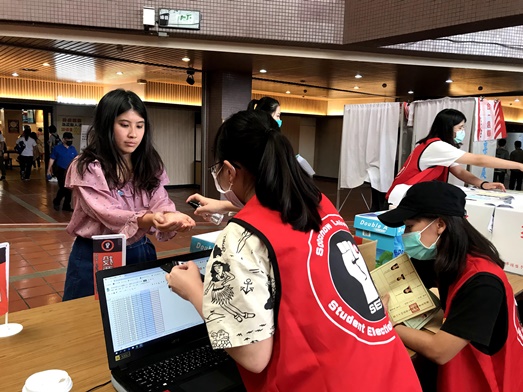 圖片標題:外雙溪選務人員協助同學投票前的前置步驟