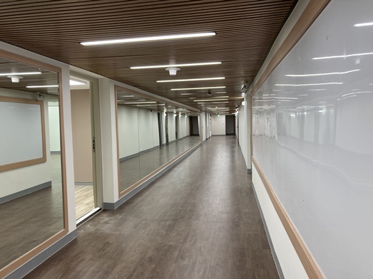 圖片標題:走道旁的牆面設置白板公佈欄以及鏡面