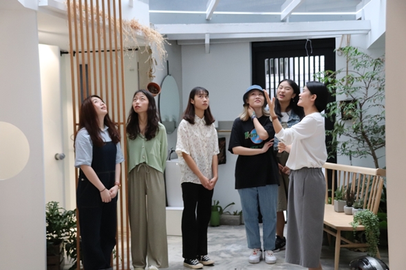 圖片標題:05戴景愉與同學介紹工作內容