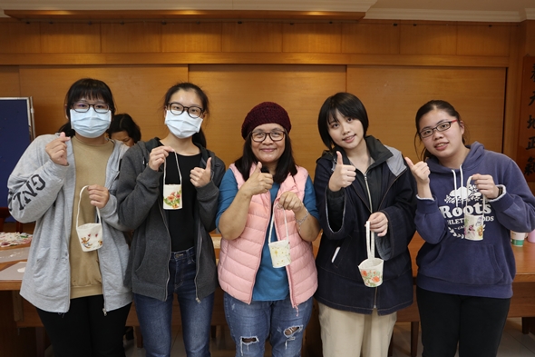 圖片標題:08同學們拿著作品與周老師合影