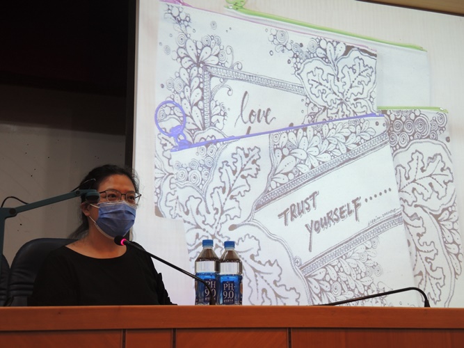 圖片標題:03講師和同學分享過去她創作的禪繞藝術的口罩套，將細節實際操作