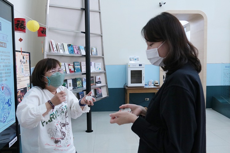 圖片標題:圖書館人員 向同學介紹童玩玩法