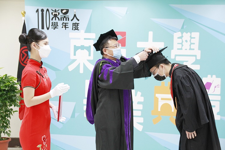 圖片標題:05潘維大校長替畢業生撥穗。