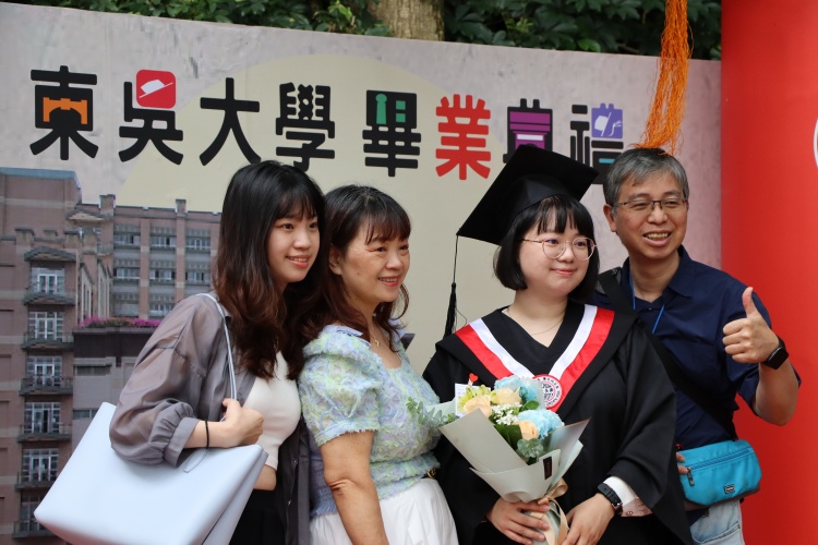 圖片標題:畢業生與親友也在校園中的打卡牆合影留念。