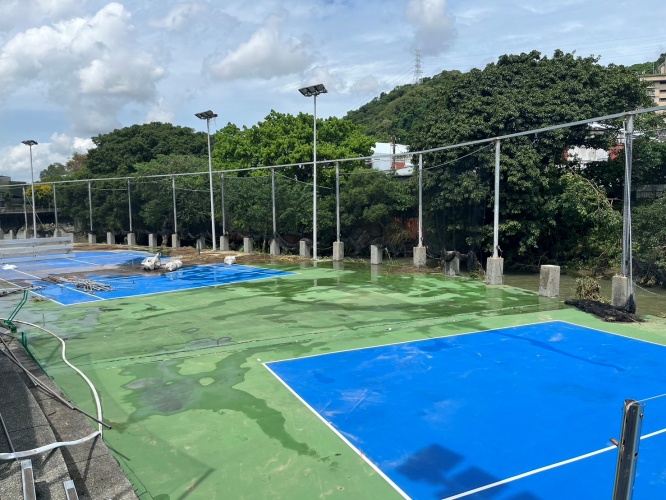 圖片標題:大雨過後，體育室立即會同總務處進行網球場地清運。